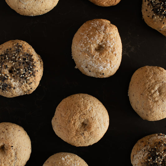 Freshly baked organic gluten-free sourdough bagels on a dark background from Leaven and Love Organic Bakehouse